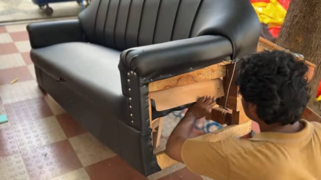 Halıcıoğlu’nda bir koltuğun döşemesi sökülmüş; sünger yenilenirken yeni kumaş koltuğa gerdirilip sabitleniyor.